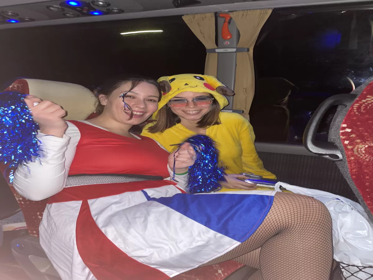 2 girls in Carnaval costumes on a bus
