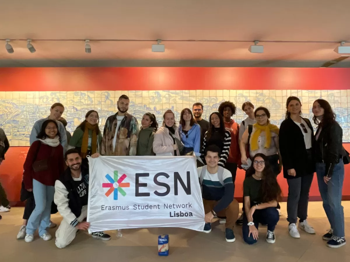 Group of Erasmus and ESNers holding the ESN Lisboa flag in the museum