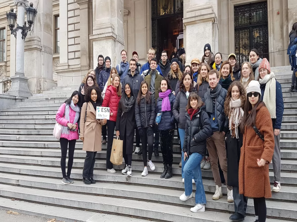 International students are standing in front of the main building of the University of Vienna