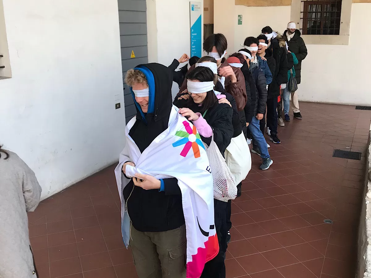 blindfolded boys forming a queue to move