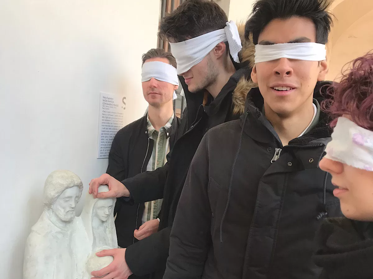 blindfolded boys touch a statue