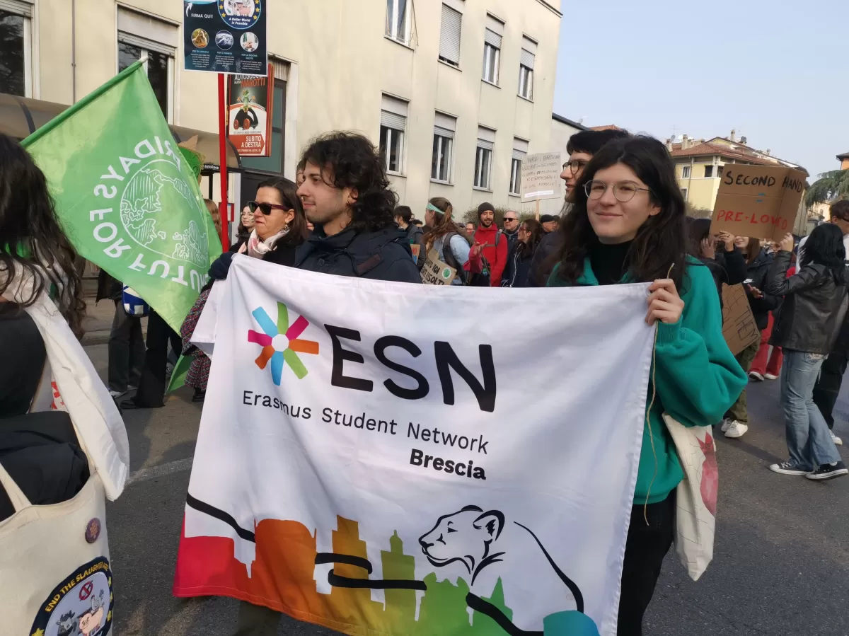 ESN Brescia volunteers and Erasmus students holding the flag during the march