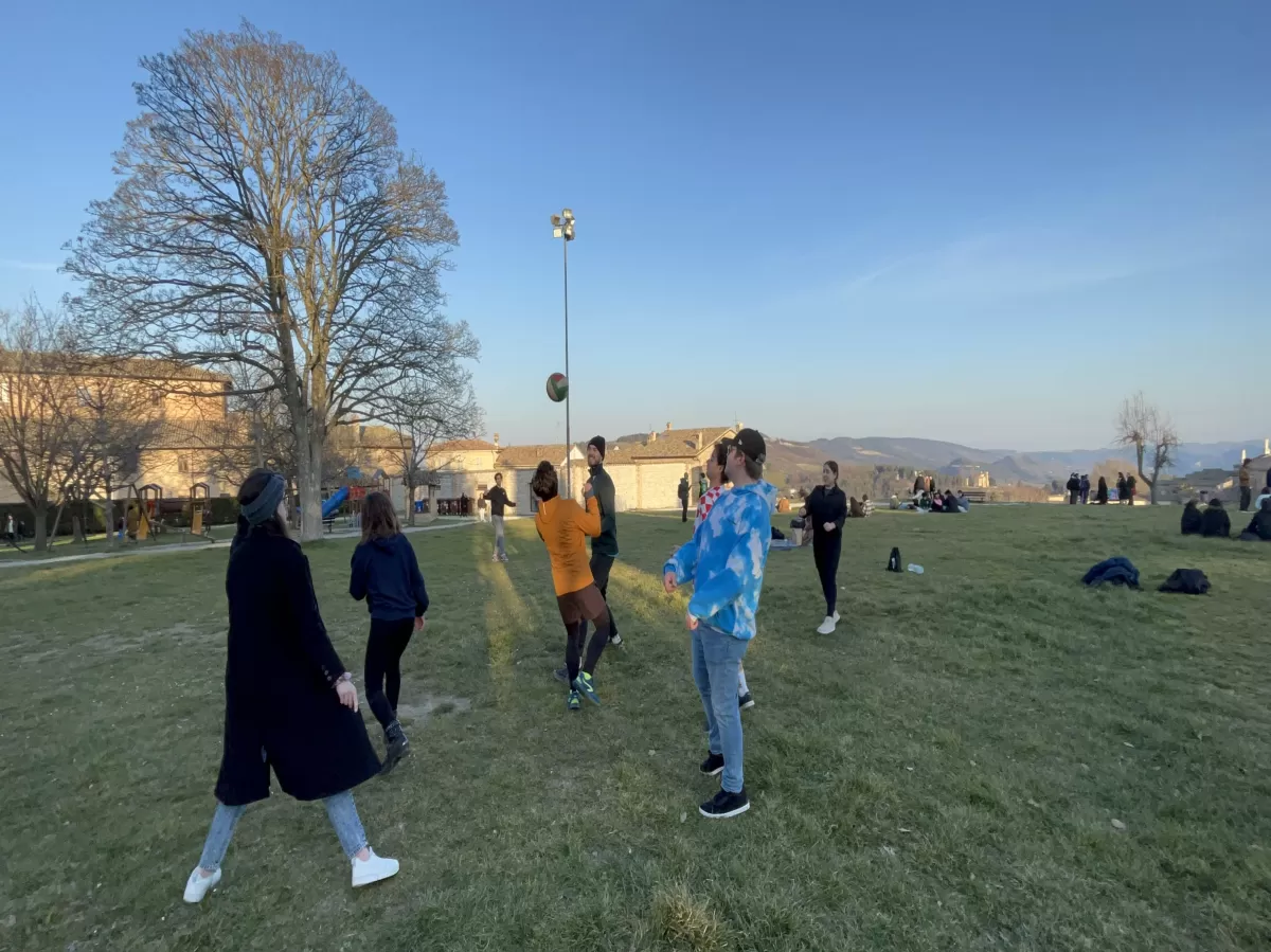 group of international students and a volunteer playing volleyball