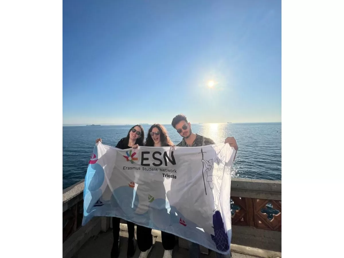 ESN volunteers in front of the sea, holding the section's flag
