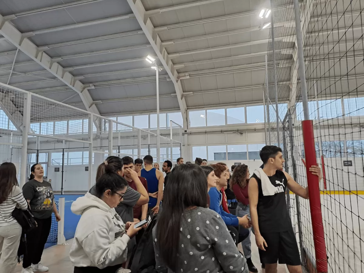 Young people watching a beach volley match