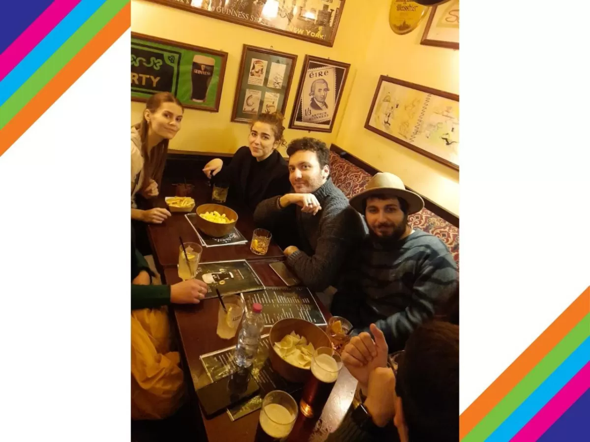 A table of volunteers and international students drinking and having fun together