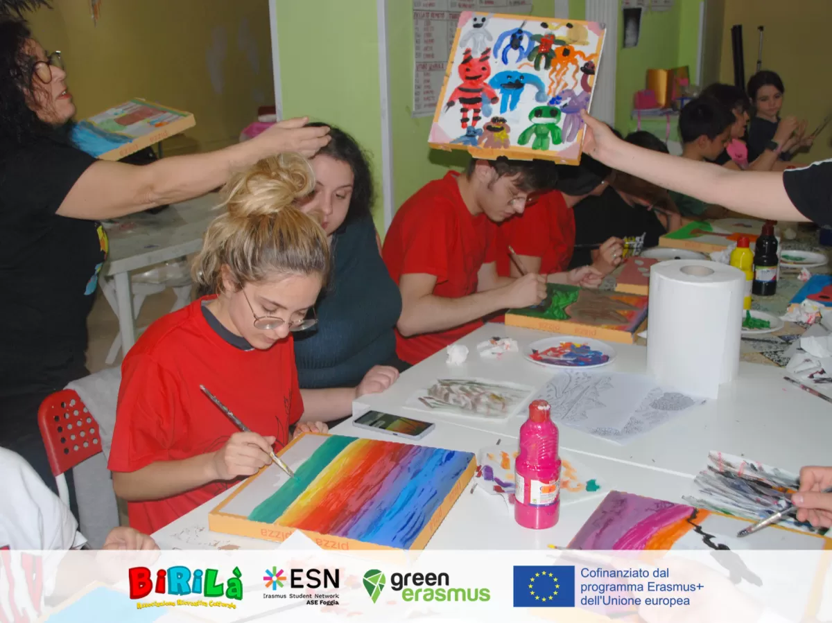 Kids and international students painting on pizza boxes