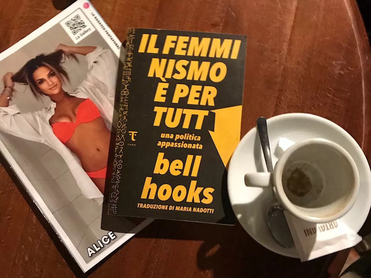 an empty cup of coffee the book and a magazine with a girl in a bathing suit