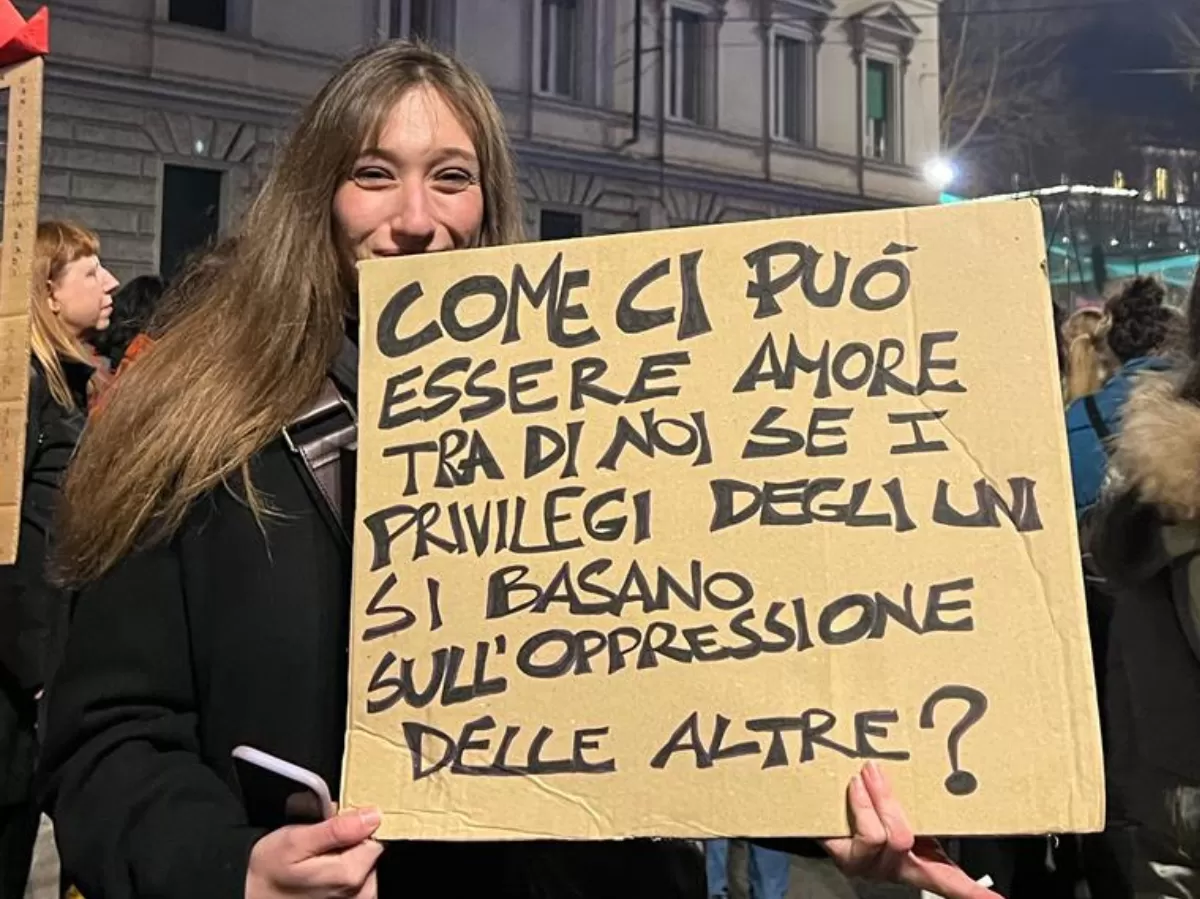 the photo shows a person holding a sign in italian