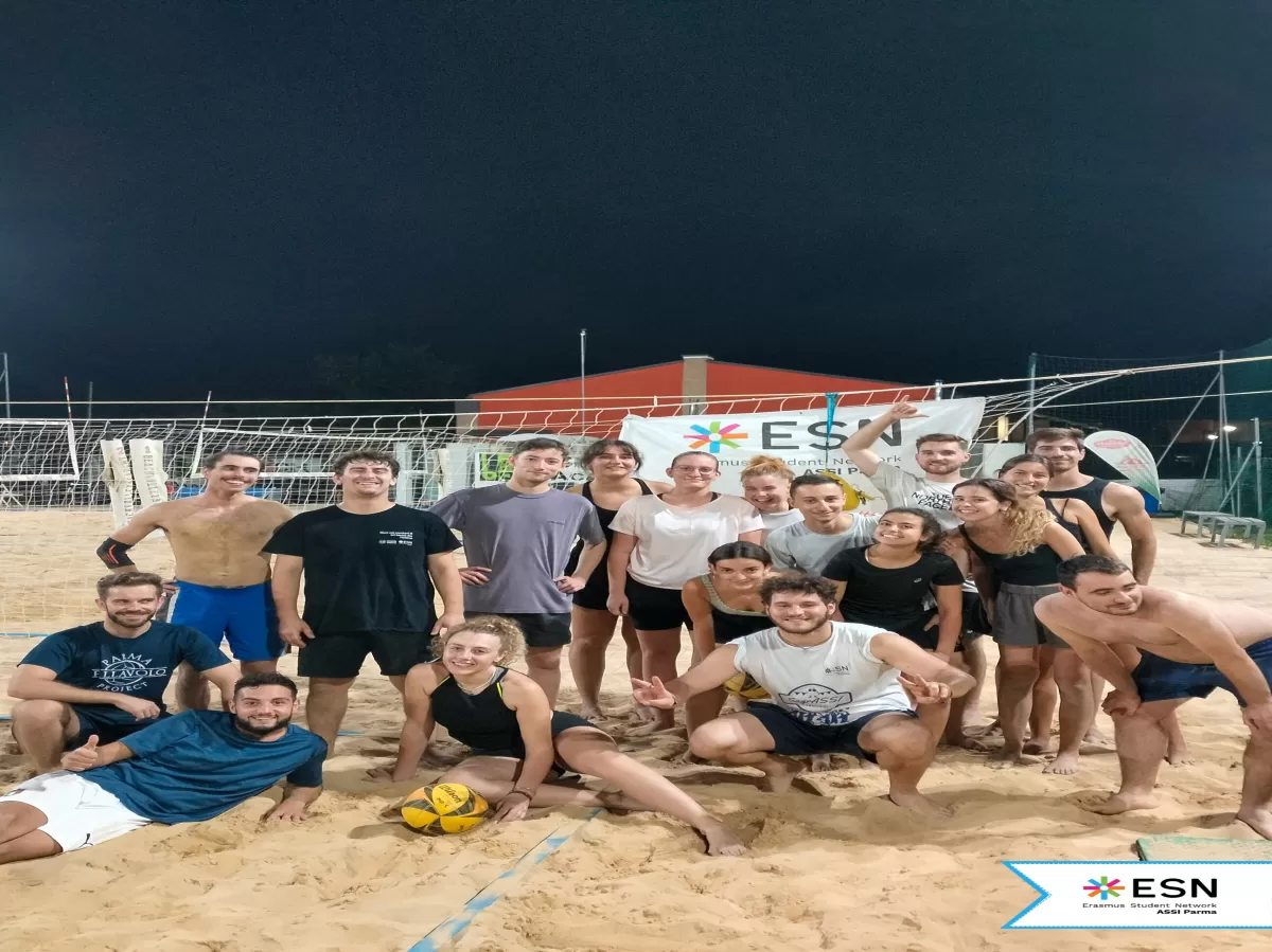 participants posing together and smiling in the beach volleyball field
