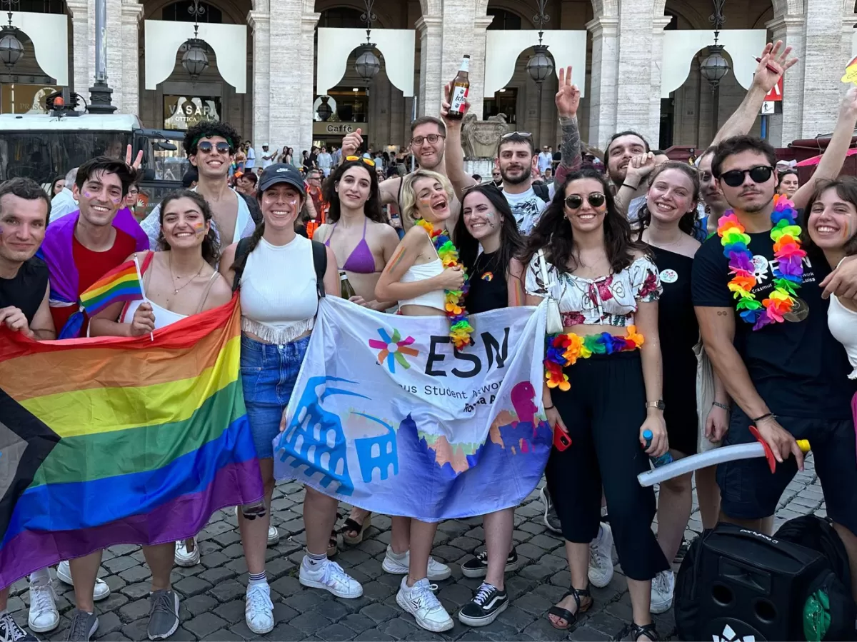 The photo shows people at the pride holding flags and signs