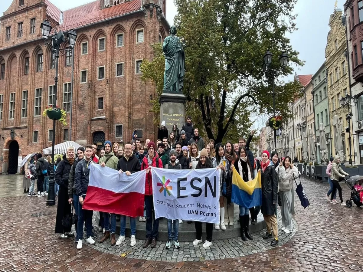 group standing with polish, Ukrainian and ESN flag on toruń main square