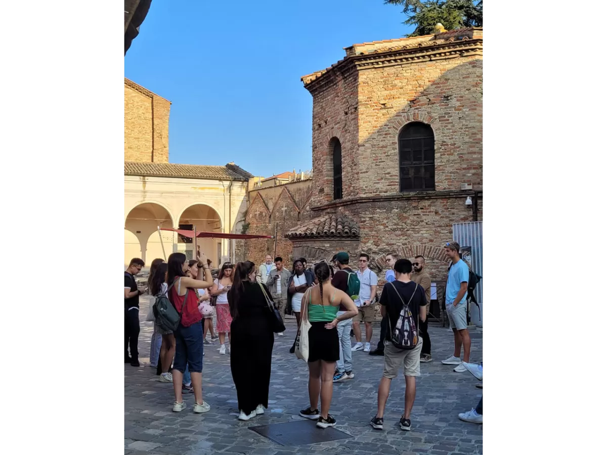 A staff member of ESN Ravenna is giving some information of the Arians' Baptistery while the ESNers are listening to him