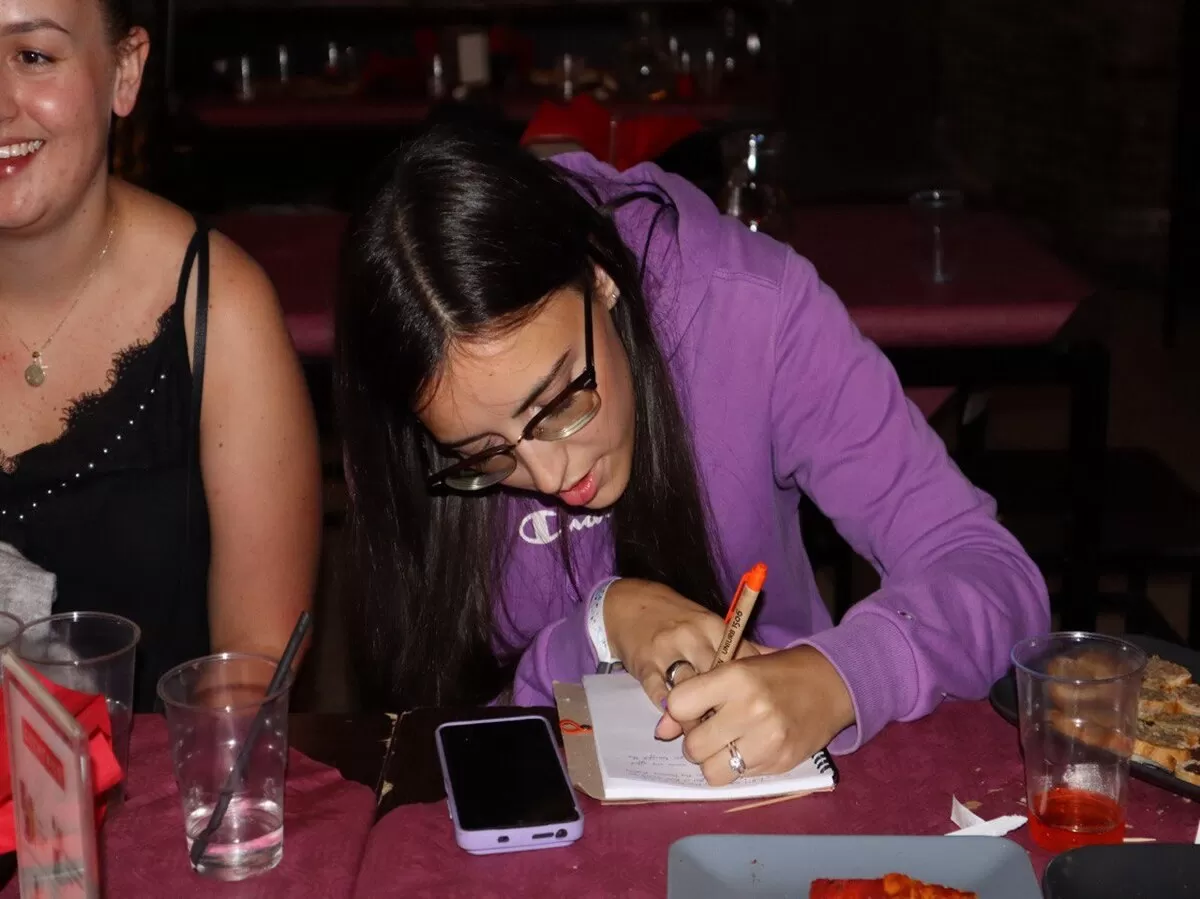 An international student is writing  her impressions on the notebook