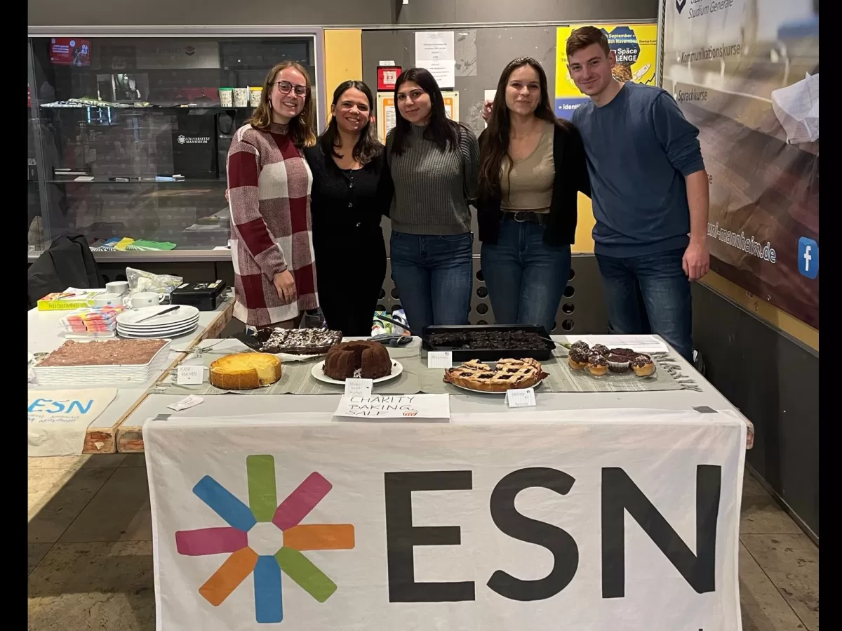 Booth at the university where the sale took place, ESN volunteers are standing behind a table full of international delicacies