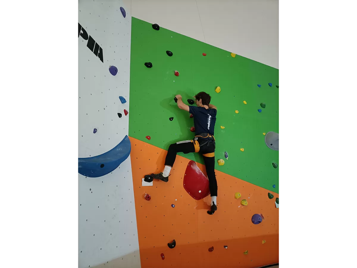 A ESNer is climbing up in a boulder wall