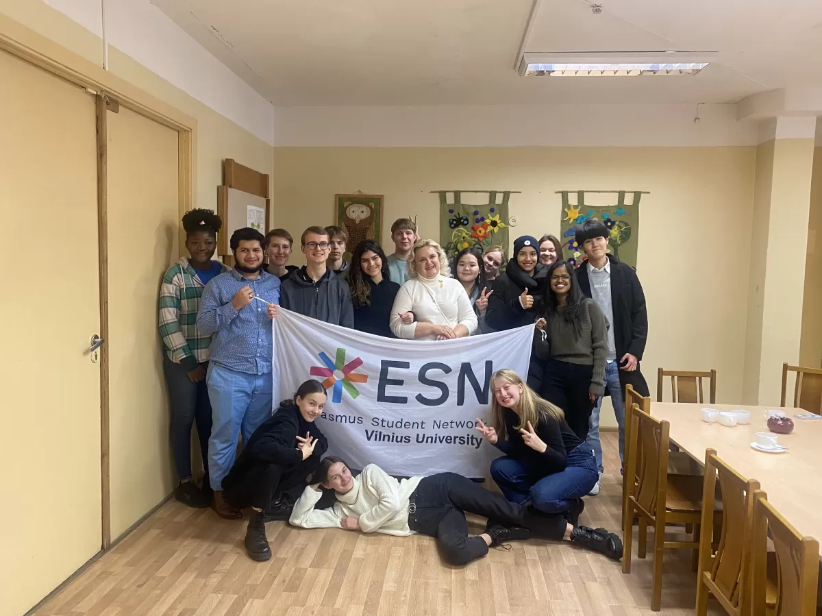 The group of international students and high school students posing for the photo while holding an ESN VU flag