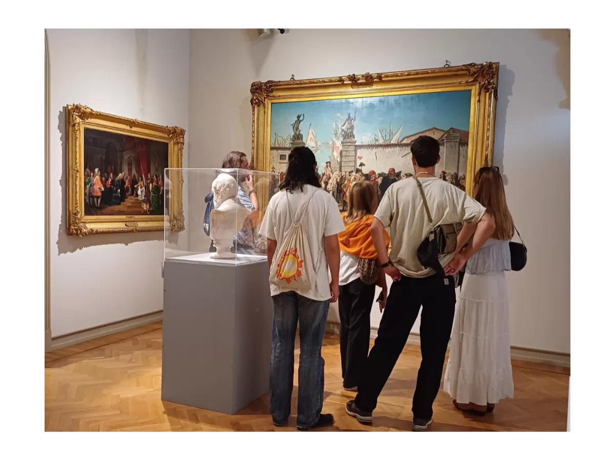 A group of Erasmus students looking at a huge painting