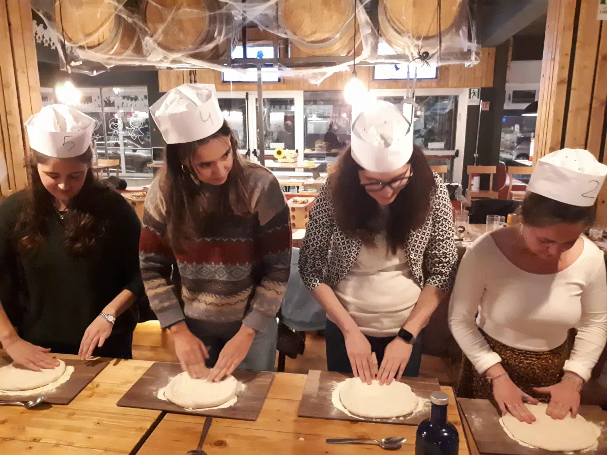 Group of international students making pizza