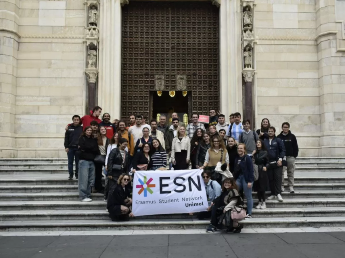 group photo of Erasmus students and volunteers in front of a church