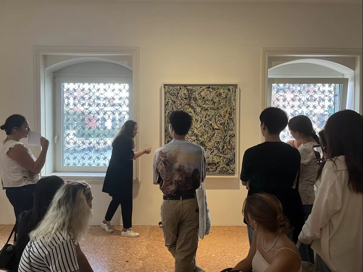 Students observing a painting while listening to the guide