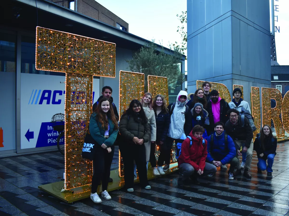 A group picture by a Tilburg sign
