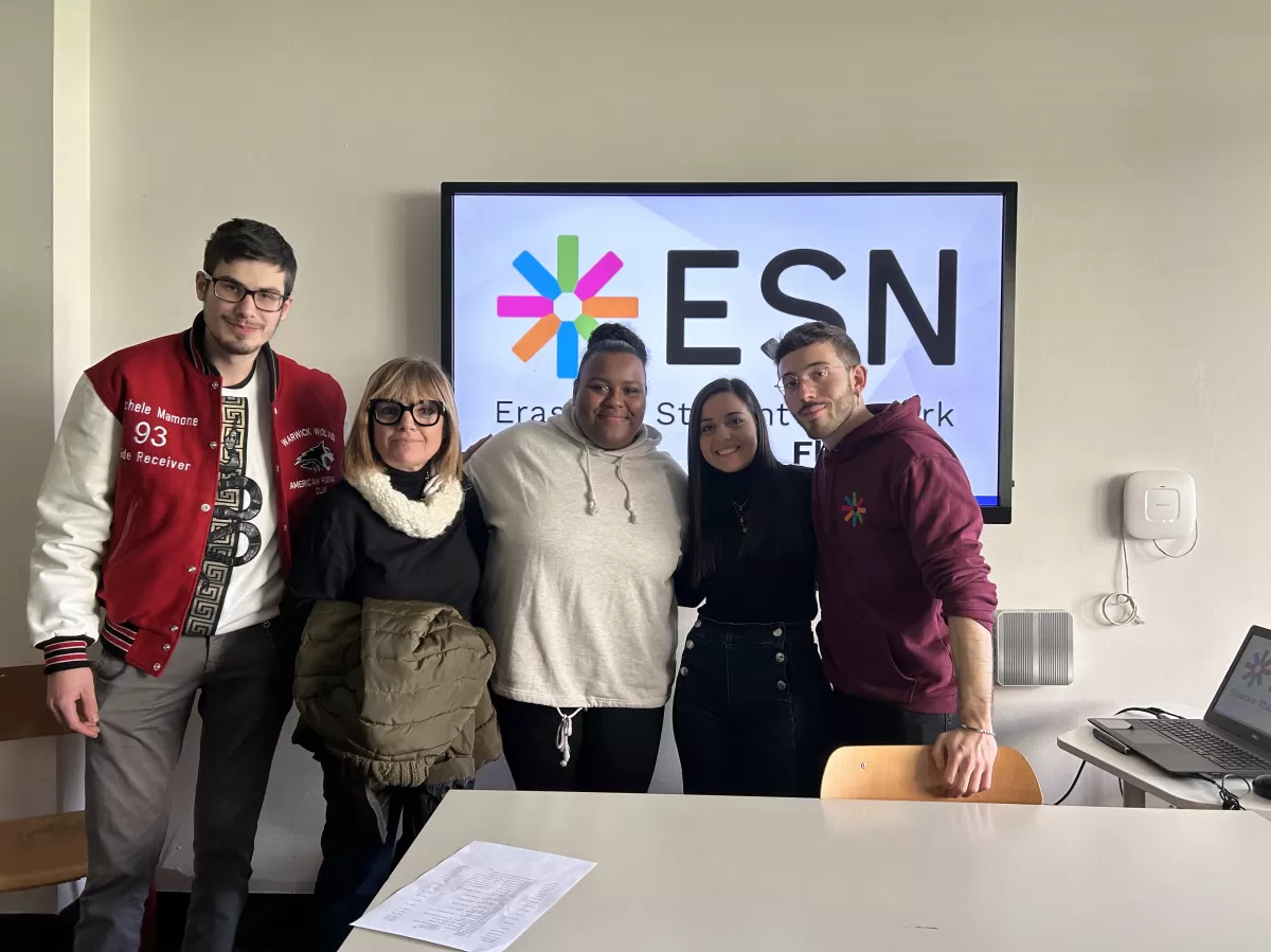 The local ESN volunteers stand in front of the screen with the teacher and the ESN Florentia logo