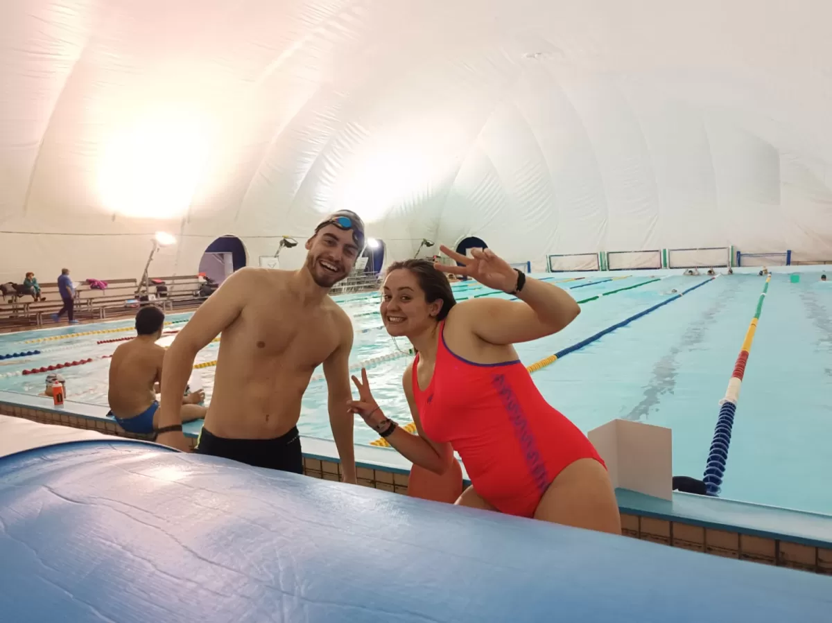 two of the participants of the swimming sesseion take a selfie in front of the pool