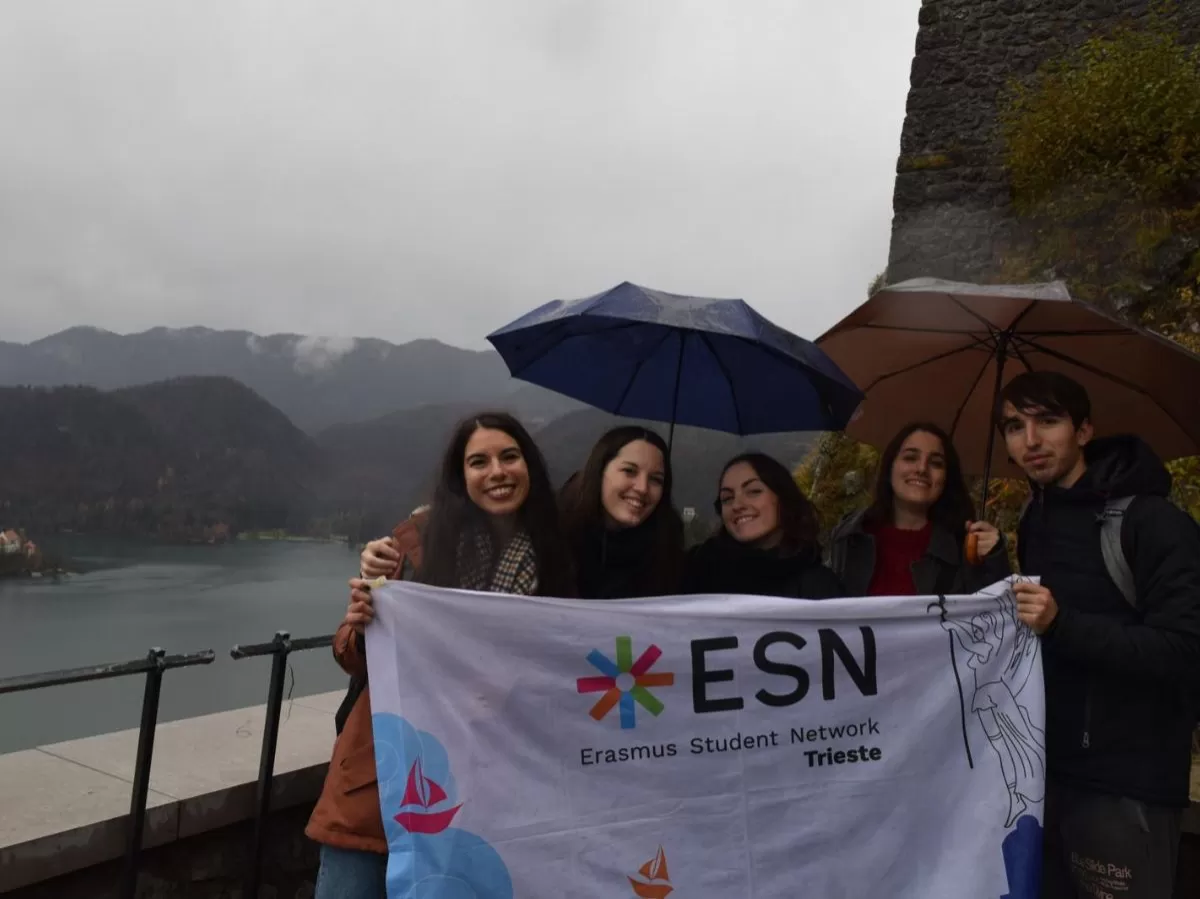Group of volunteers in Bled holding ESN Trieste's flag