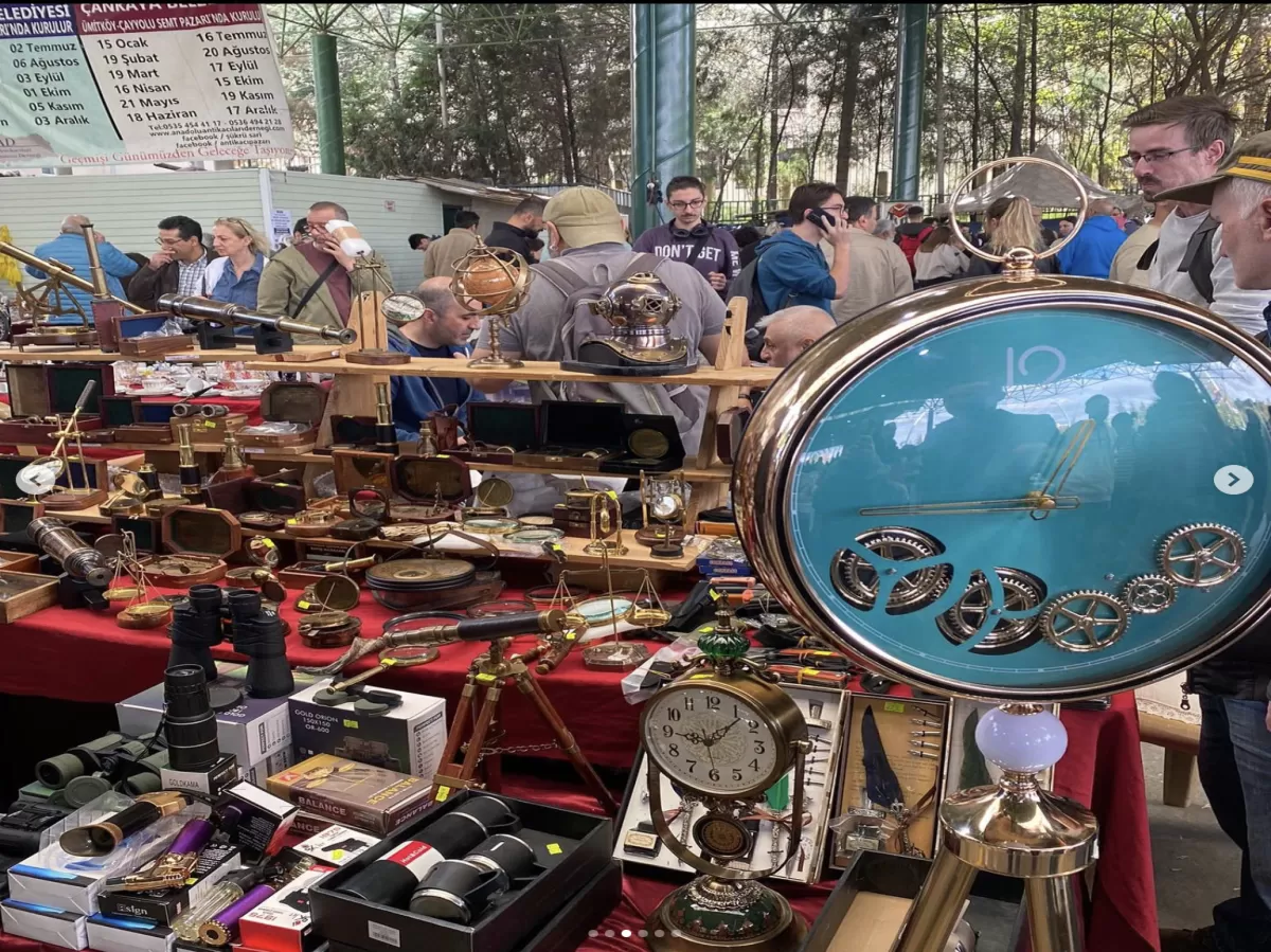 Photo of various antique trinkets on sale such as bronze clocks, table ornaments, binoculars etc.