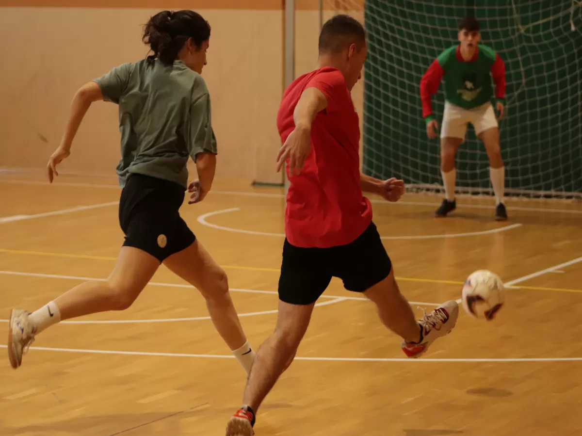 Students playing futsal in a hall