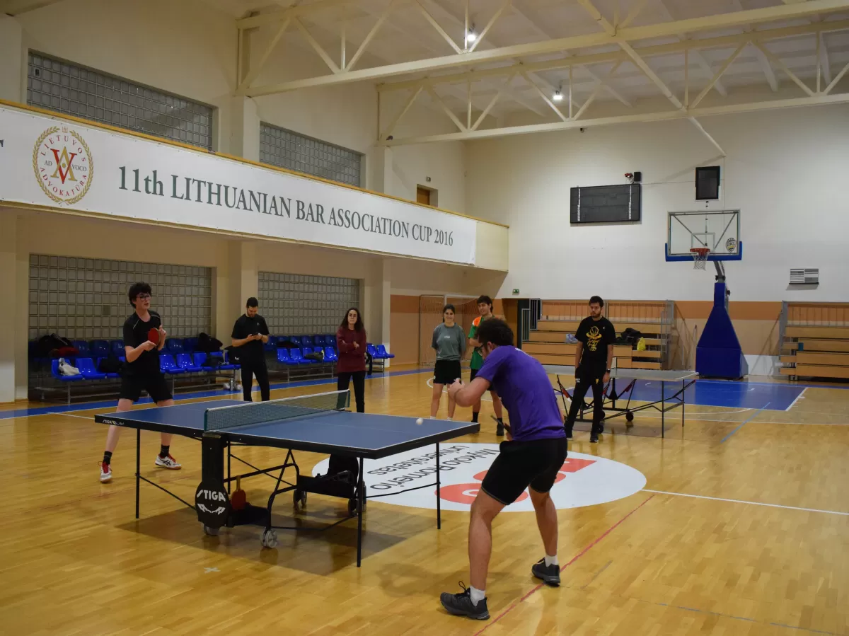 Students playing table tennis in a hall