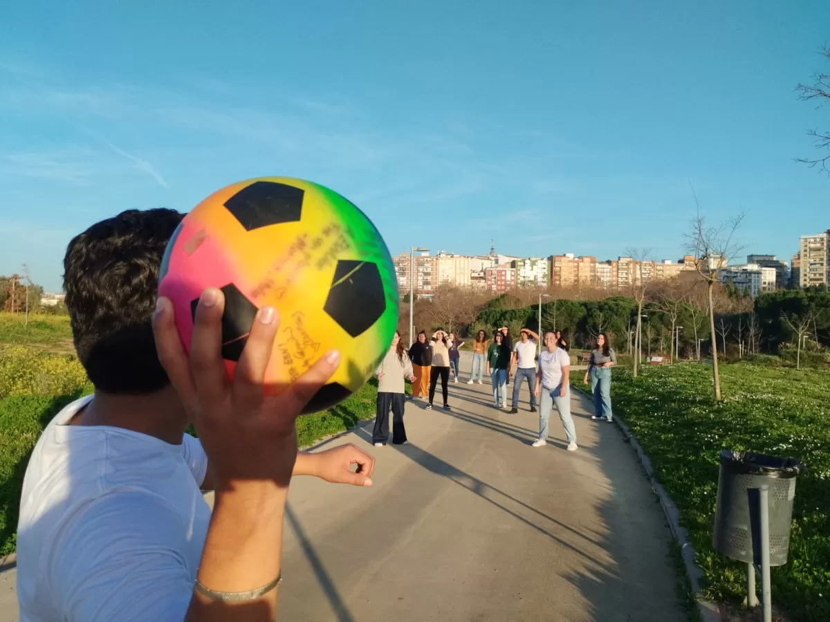 The photo shows an Erasmus student throwing a coloured ball.