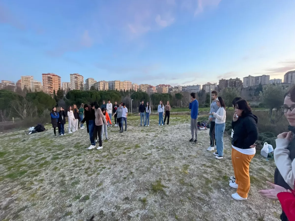 The picture shows several Erasmus students playing a game in pairs in a beautiful landscape.
