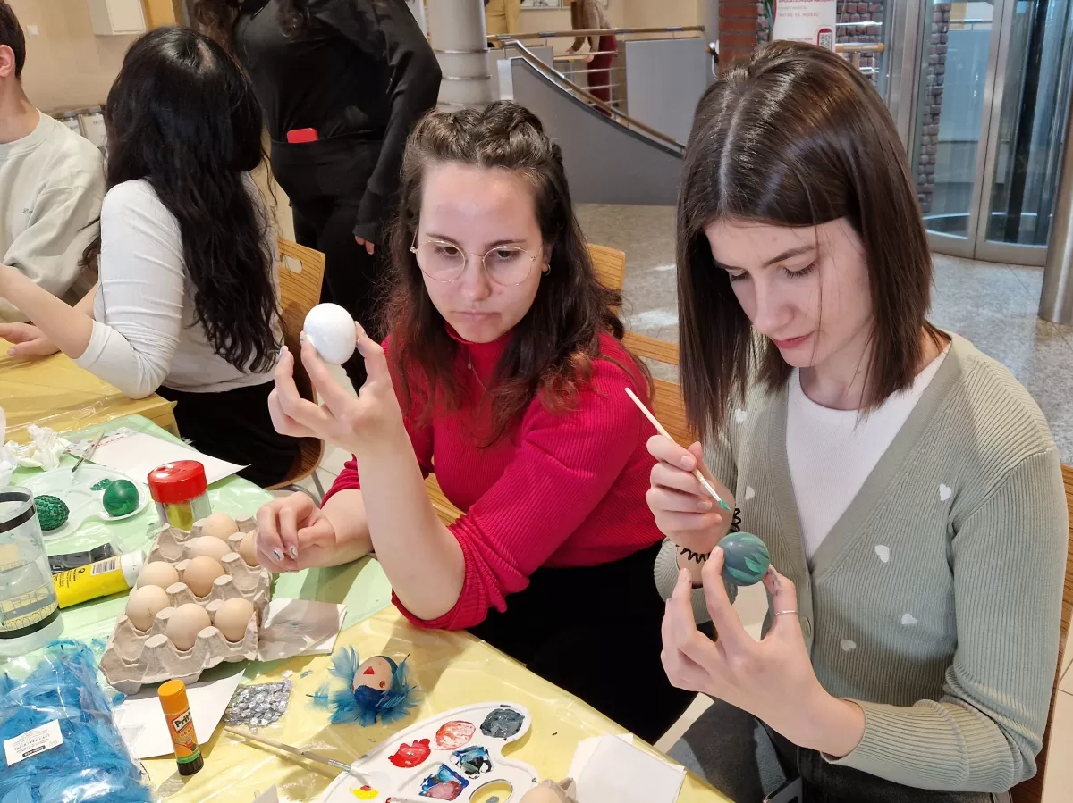 International students painting eggs
