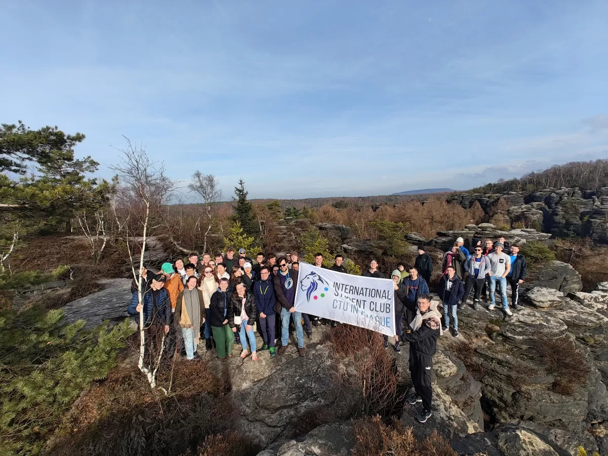 A group of international students standing on a rock.