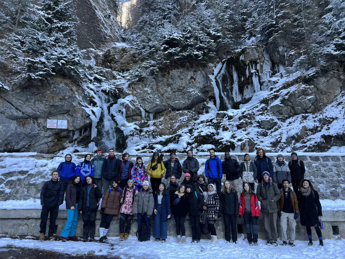 It is a group picture (33 people) in January (they are wearing winter clothes) and in the background is a frozen waterfall.