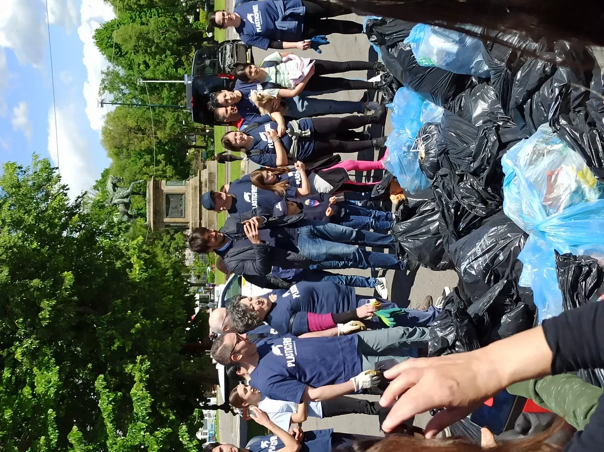 Group of people in front of many garbage bags