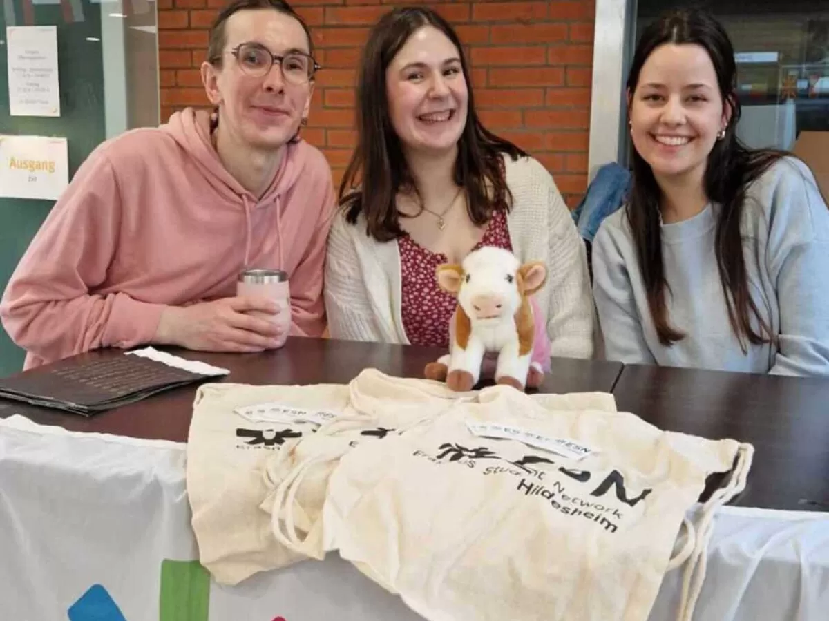 Three people standing behind a table that has ESN bags on it.