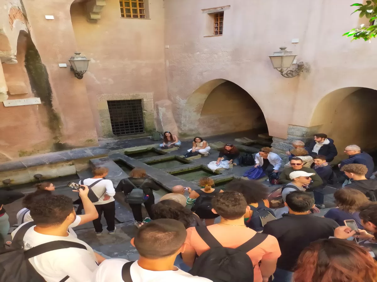 Group of Erasmus students at the medieval wash house in Cefalù