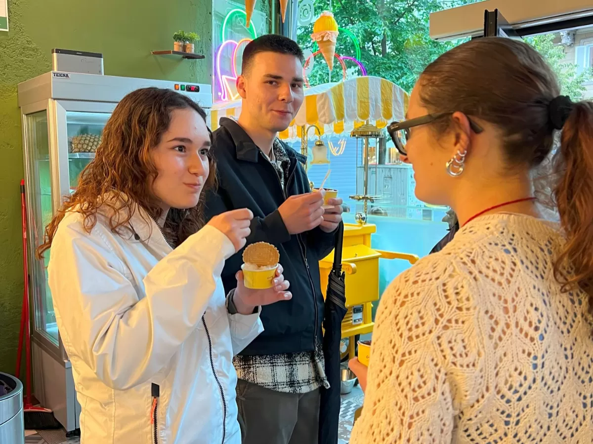 Three of the participants are enjoying their gelato and talking to each other.