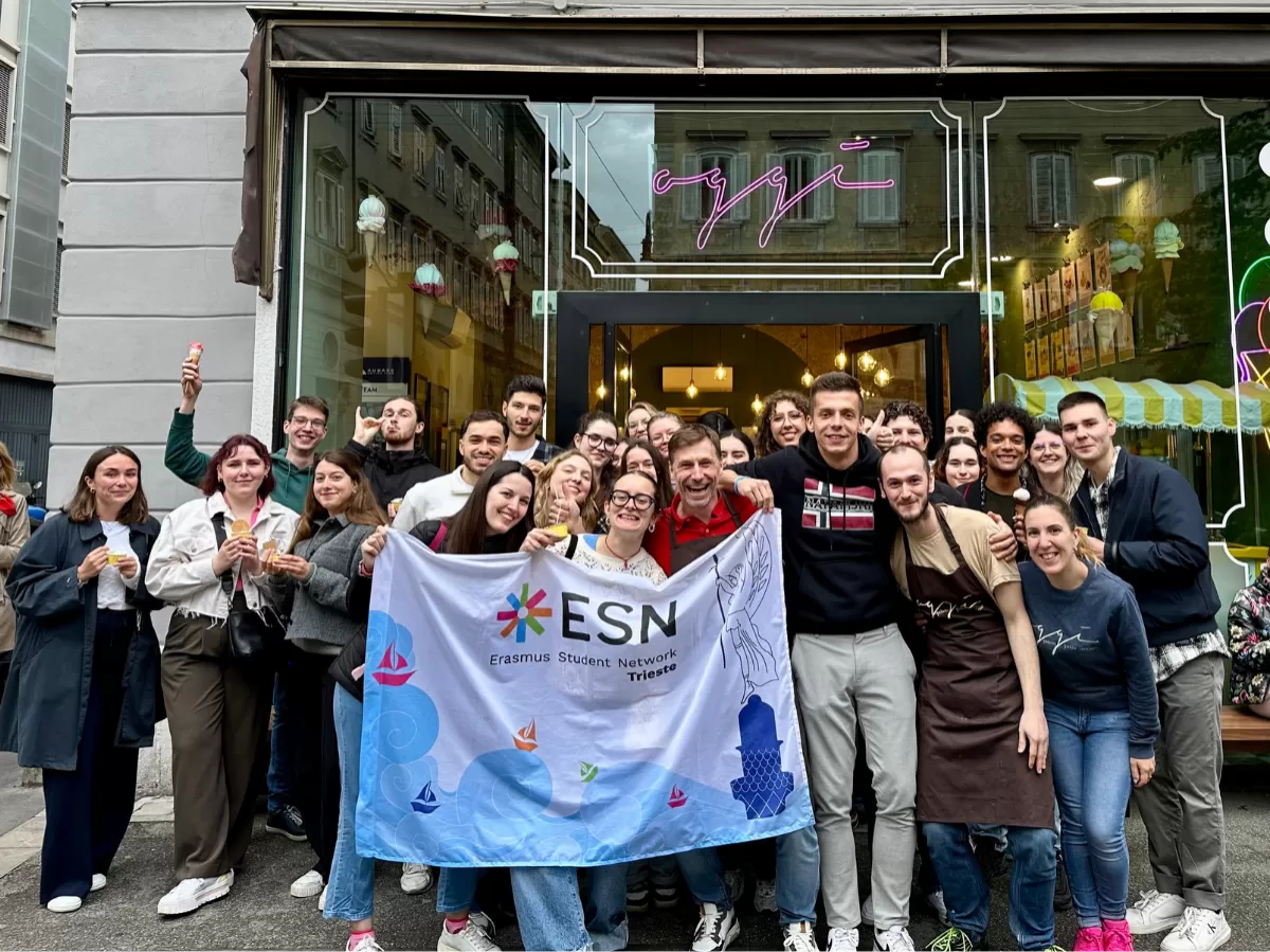 A group picture in front of Oggi gelato with its owner. The participants are holding our section's flag.