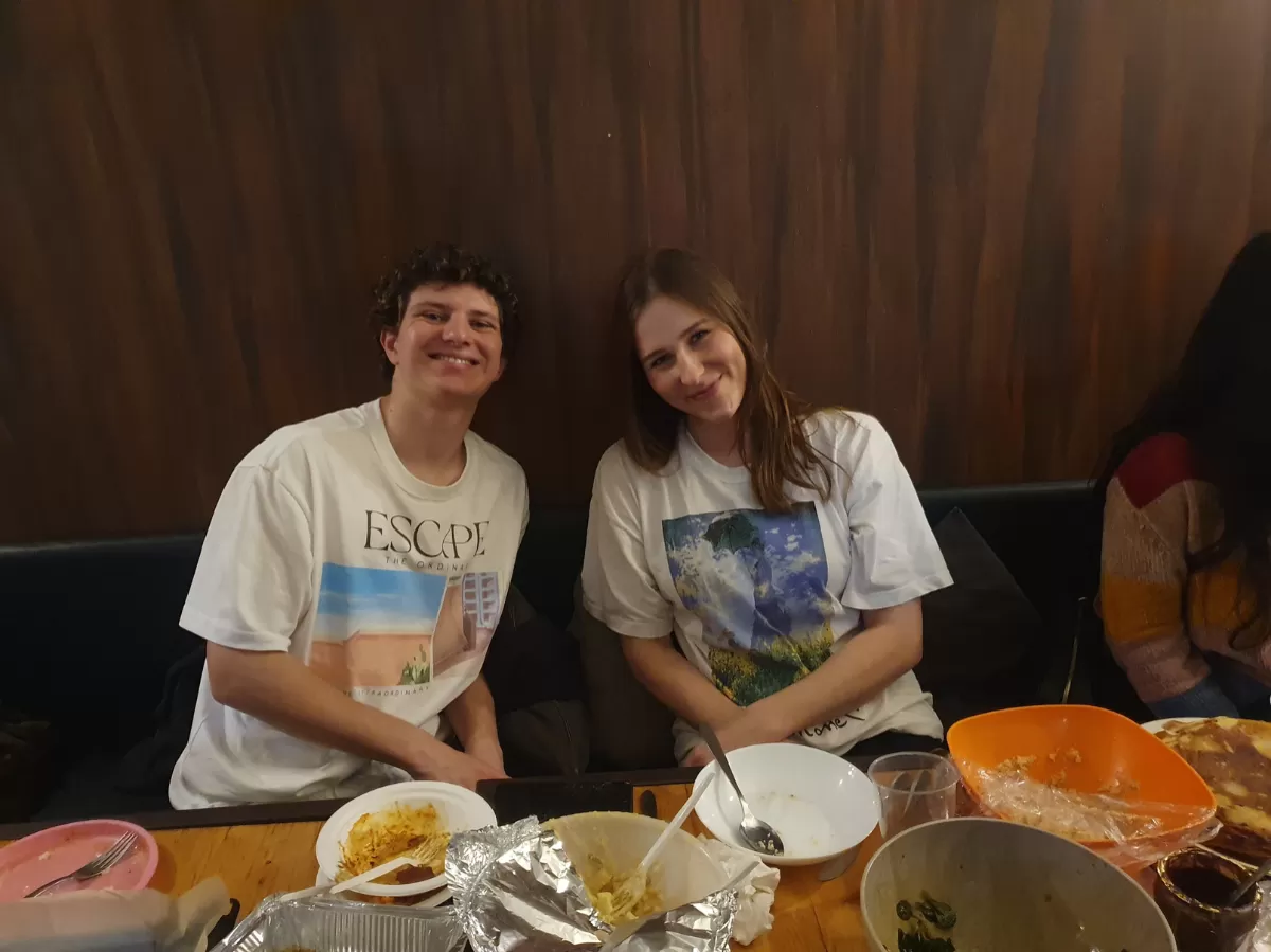 Two Erasmus students sit at the table and smile at the camera
