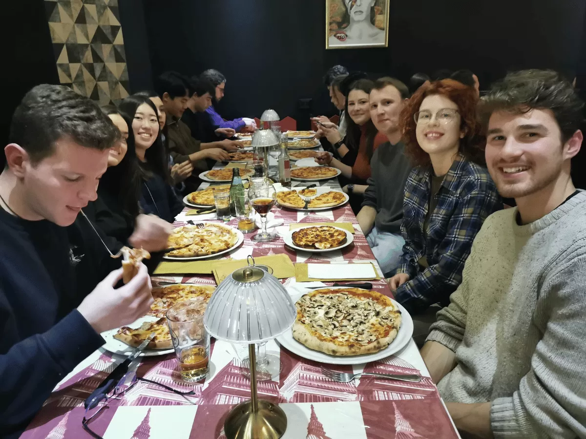 group of international students eating pizza