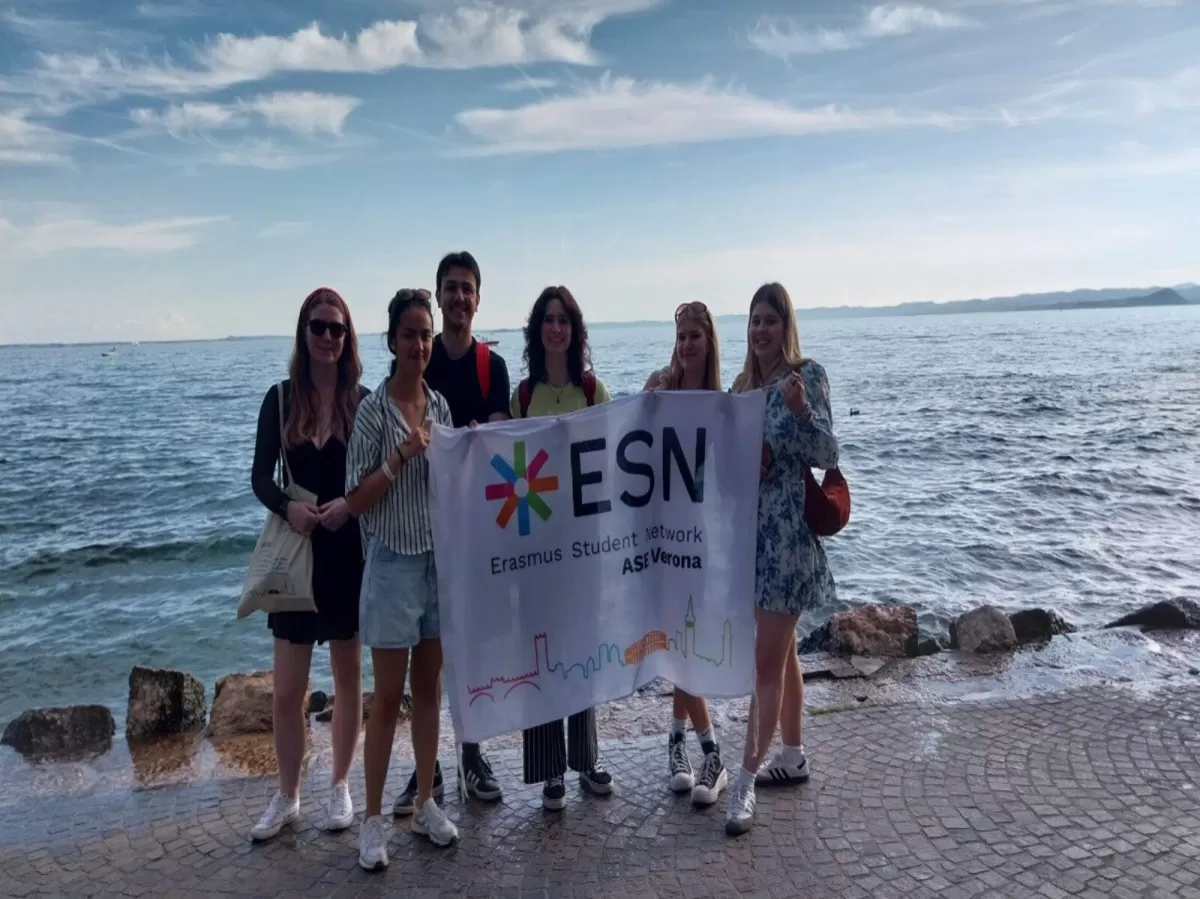 Group picture in front of the lake holding the ESN ASE Verona flag