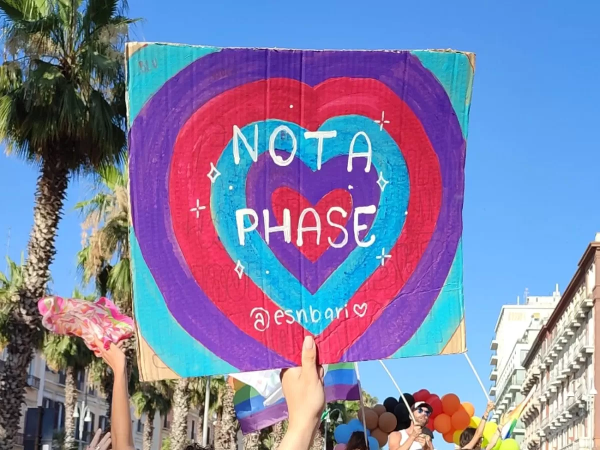 a sign reading "not a phase" and the tag of ESN Bari is raised during the parade as a symbol of bisexual pride