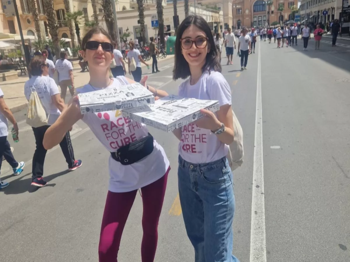 two volunteers bring focaccia, typical Bari food, to Erasmus students after the race