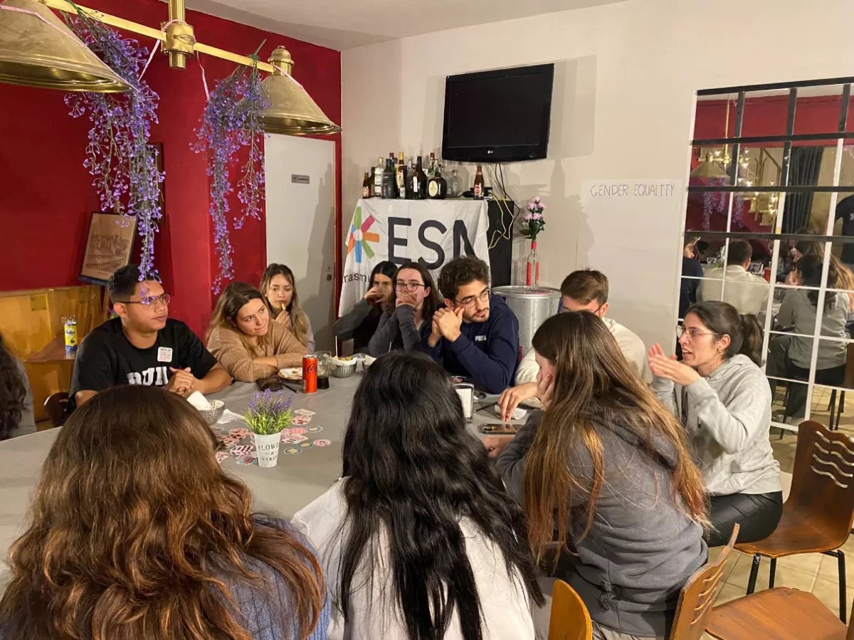 Group of international students talking inside a coffee shop