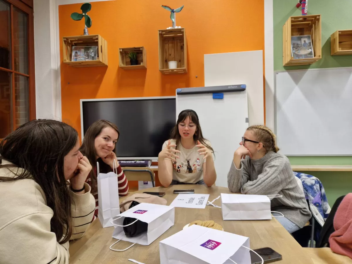 Group engaging in a conversation with a female game developer.