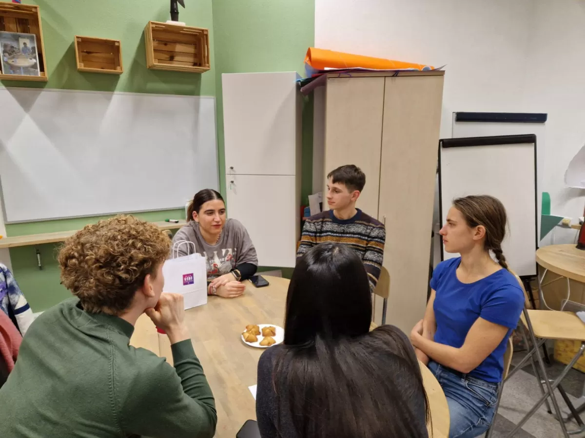 Group engaging in a conversation with a female mechanical engineering student.